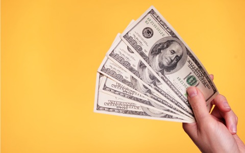 a-hand-holding-five-100-bills